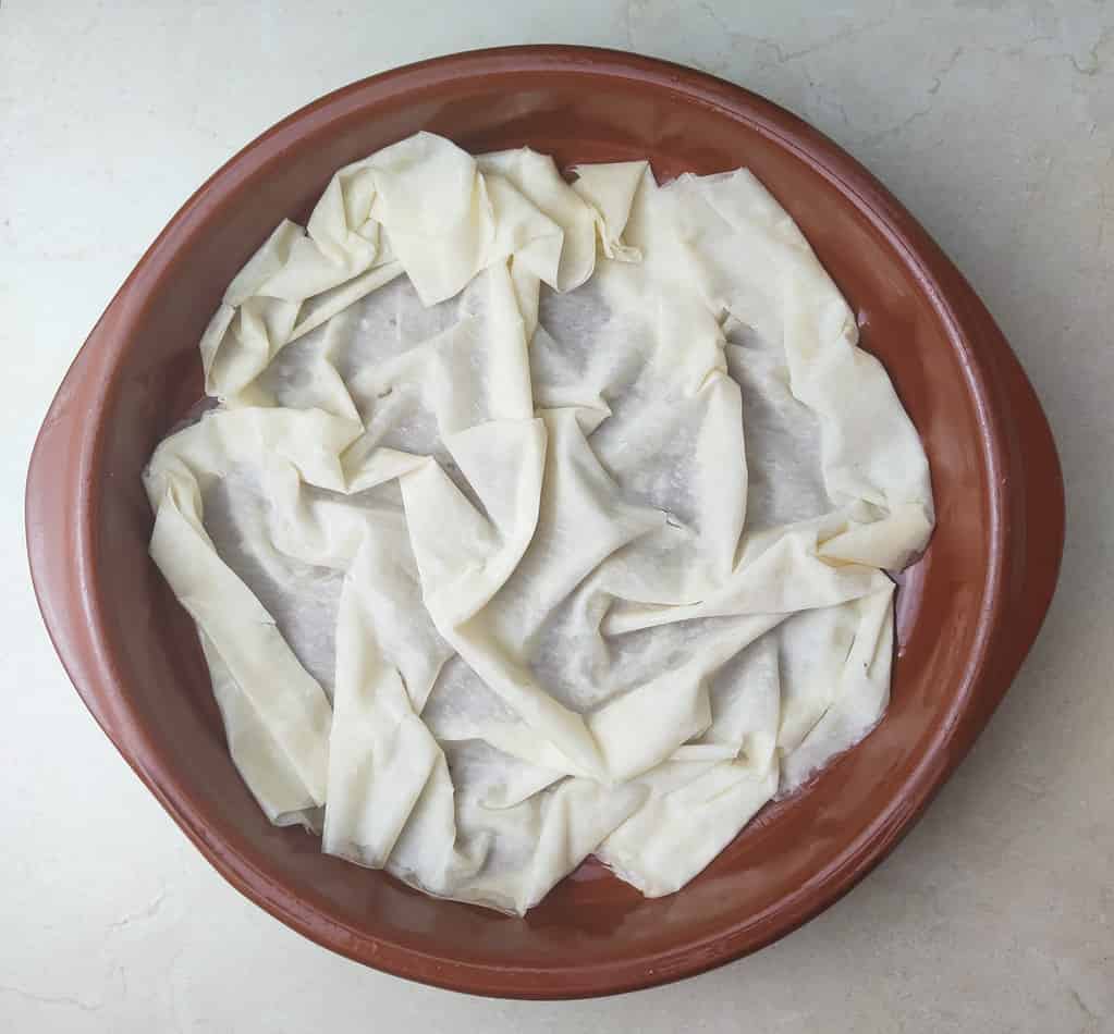 image showing how to place the phyllo sheet at the bottow of the pie pan 