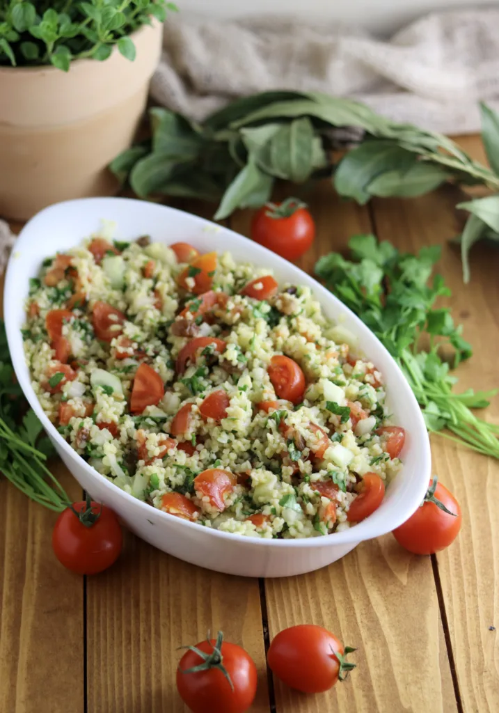 image showing taboule oriental served on the table with parsley and marjoram leaves in the background