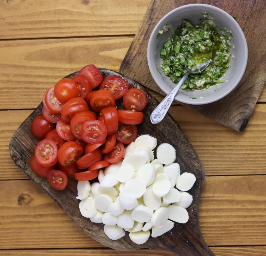 step: image showing how to slice the tomatoes and mozzarella cheese together with parsley and garlic in olive oil for the filling