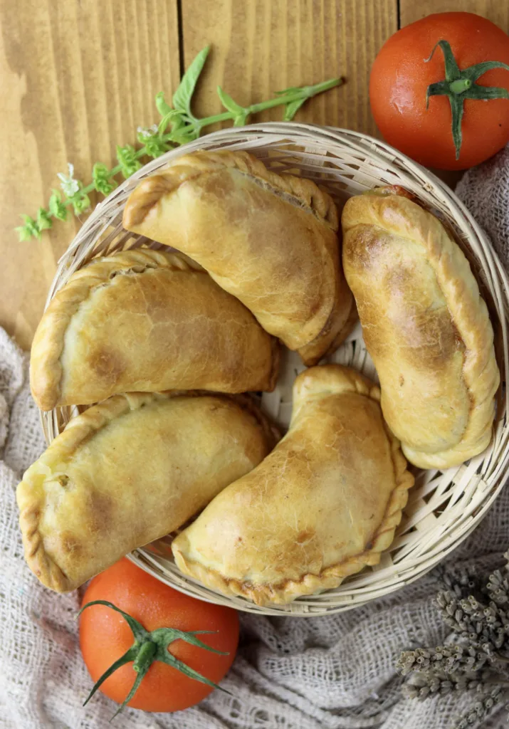 placing caprese empanadas in a bread basket