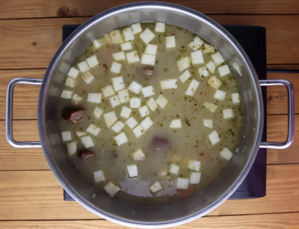 step six: adding the chopped vegetables and stir fried garlic with onions to the pot with boiling soup