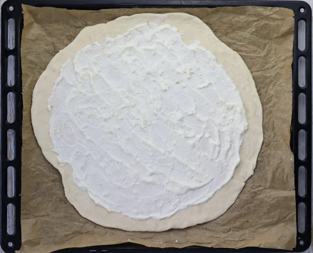 step 8: adding creamy garlic sauce to pizza dough