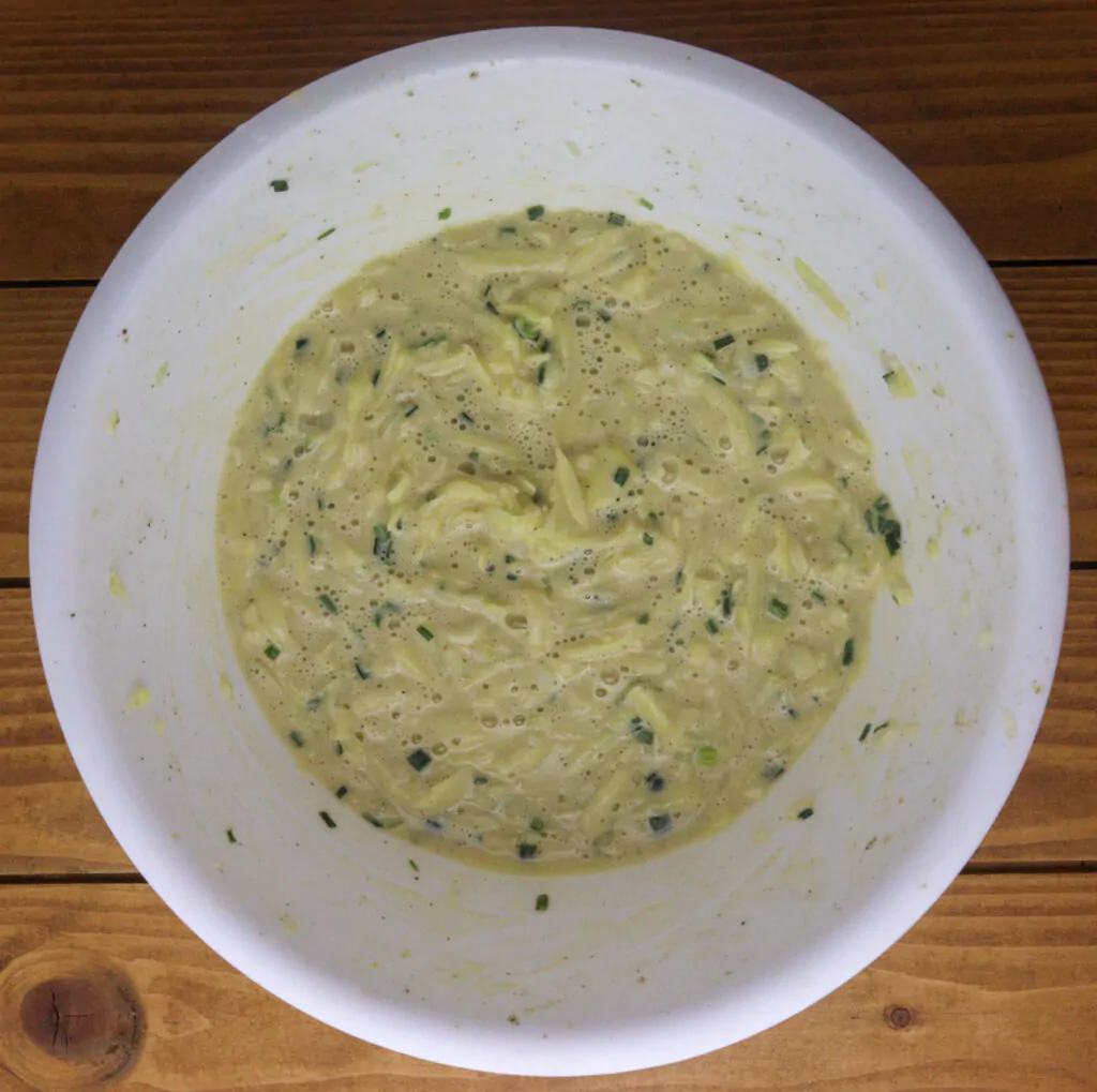 how to prepare the potato batter, mixing together the seasoning, flour and eggs mixture and shredded potatoes