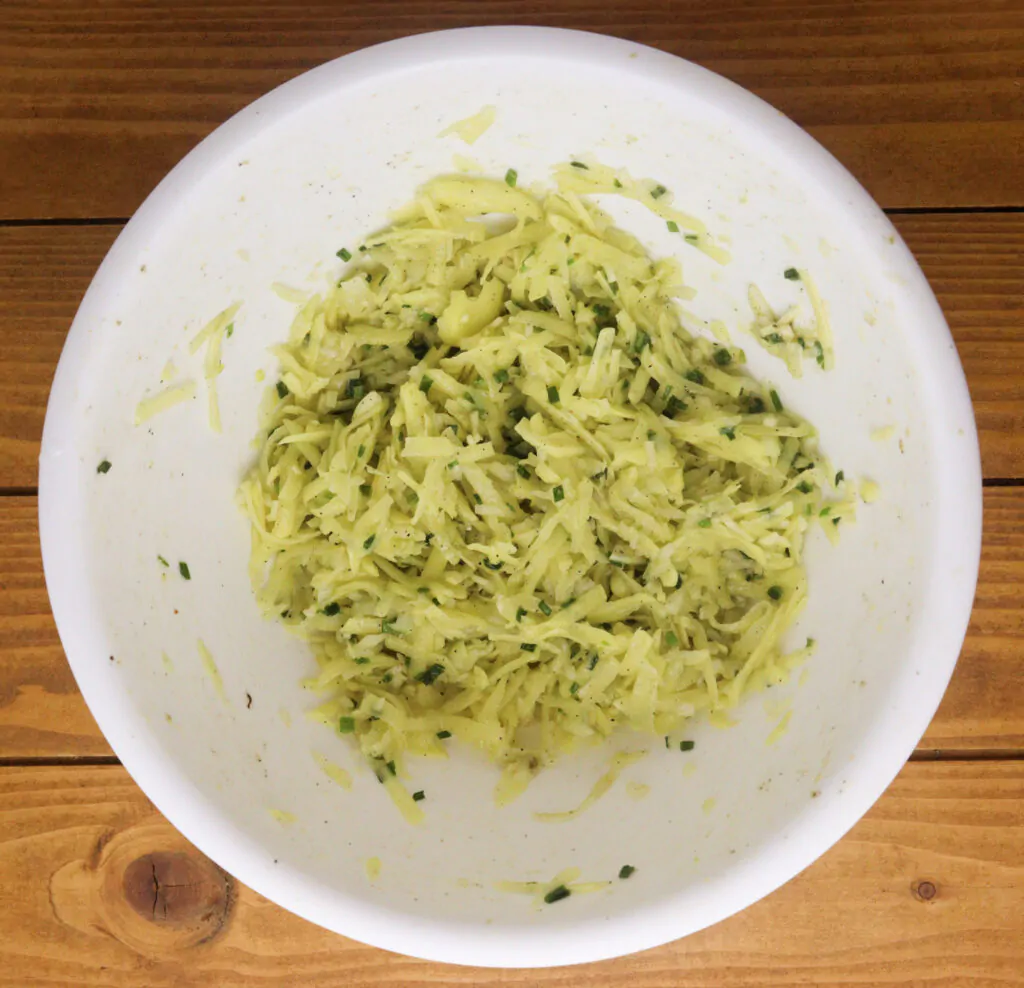 how to prepare the potato batter, mixing together the seasoning, flour and eggs mixture and shredded potatoes