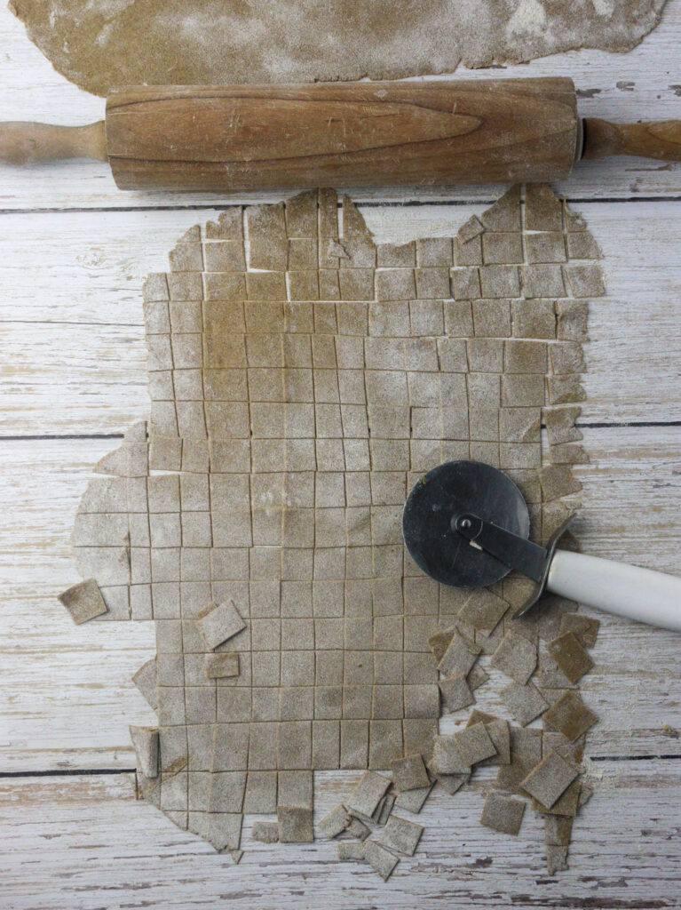 image of cutting the rolled dough into small rectangular noodles 