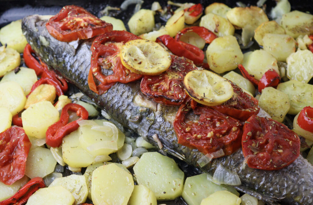 Image showing how to stack tomatoes and lemon slices on top of the fish for more moisture. 