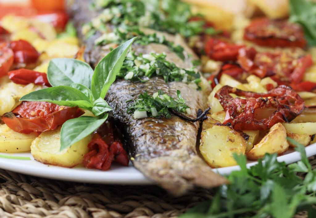 image featuruing a tail of a delicious baked grey mullet served on a plate