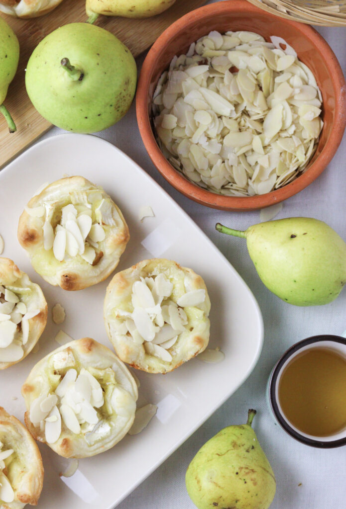 image of gorgeous brie and pear puff pastry bites served with fresh pears, almonds and honey