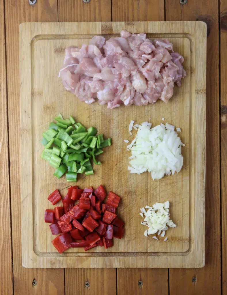 Image showing how to slice the vegetables, garlic, onion and how to slice the chicken into smaller pieces 