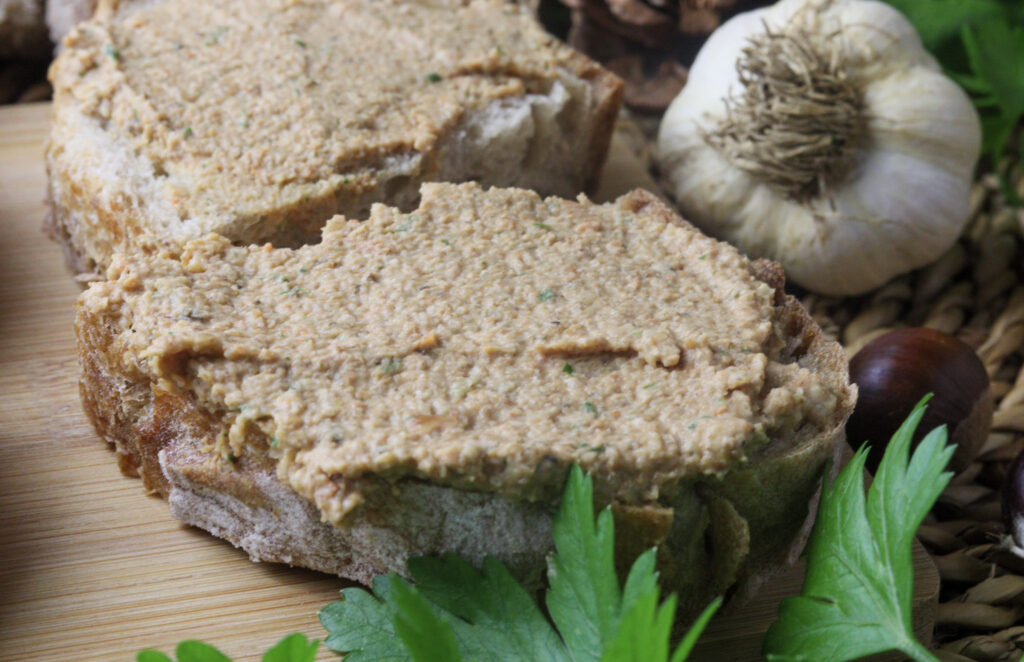 image of saffron milk cap pate spread on a piece of rustic bread 